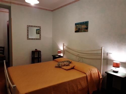 a bedroom with a bed with an orange blanket at Agriturismo Colleverde Capalbio in Capalbio