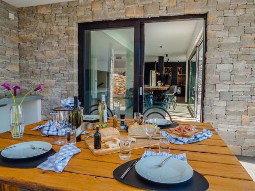 a wooden table with plates and wine glasses on it at Cà Veia in Vrbnik