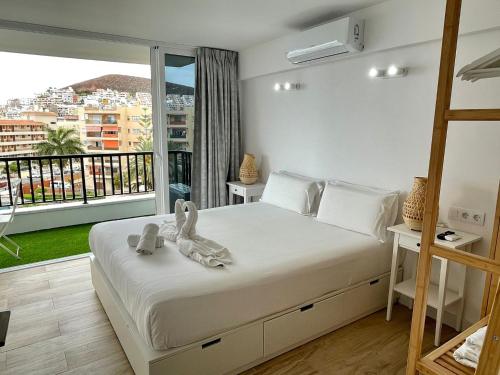 a bedroom with a large bed with a balcony at Style & Sea FREEWIFI in Los Cristianos