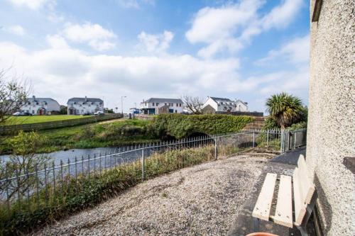 a bench sitting on a wall next to a river at Fishermans Cottage Stunning Two Bedroom with Views close to town in Bundoran
