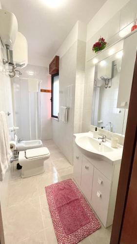 a white bathroom with a toilet and a sink at Belvedere Home in Rodi Garganico