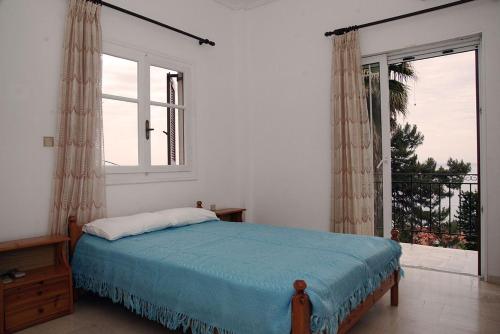 a bedroom with a bed and a large window at Sea La Vie Apartment Koroni in Koroni