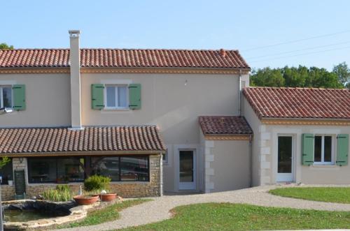 a house with red roofs and a yard at La Ferme Des Vergnes in Gabillou