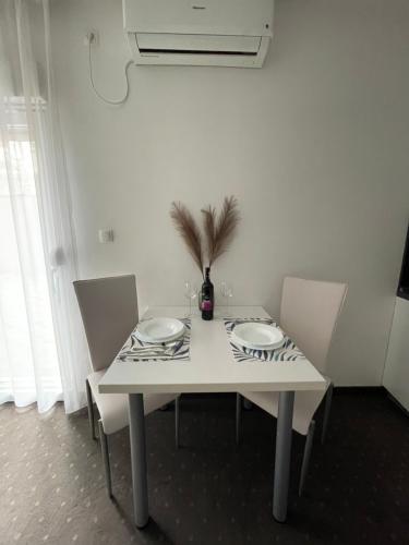 a white table with two plates and a plant on it at Apartments & Rooms Villa Zaad FREE PRIVATE PARKING in Mostar