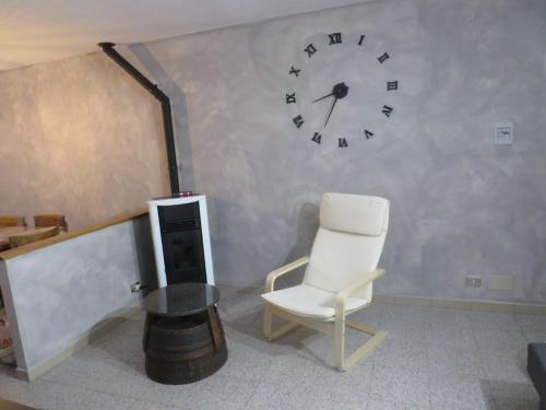 Pokój z krzesłem i zegarem na ścianie w obiekcie Marta's house w mieście Prebernardo