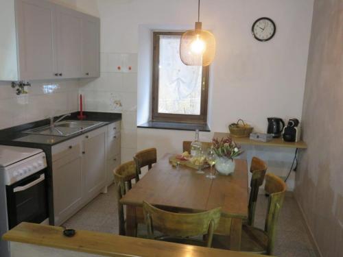 a kitchen with a table and chairs and a clock on the wall at Marta's house in Prebernardo