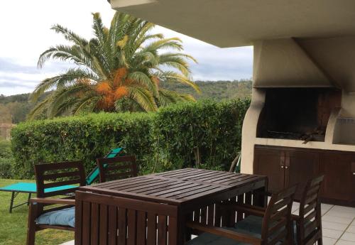 a patio with a table and chairs and a palm tree at Favone Mini Villa Playa del Oro in Favone
