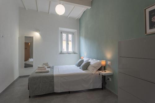a white bedroom with a bed and a window at Appartamento Casa Nina in San Miniato