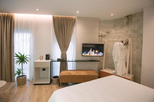 a hotel room with a bed and a dress on a rack at Boulevard Boutique Aparthotel in Korçë