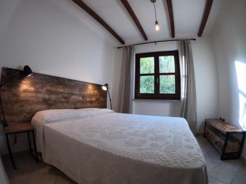 una camera con un grande letto e una finestra di Fenile Apartments a Santa Maria Navarrese