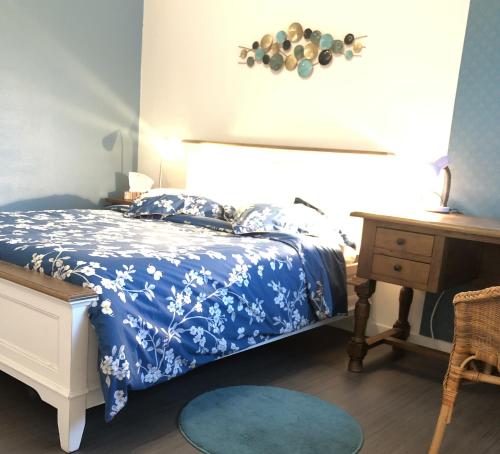 une chambre avec un lit bleu et blanc et un bureau dans l'établissement BedinReims 