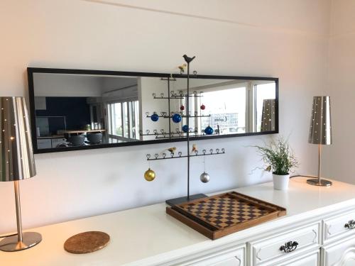 a mirror on a wall above a table with a board at BedinReims "blue bottle"quiet and close to center free parking and wifi free ideal 5 à 6 Adultes in Reims