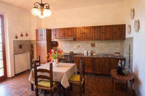 una cocina con una mesa con un jarrón de flores. en Poggio Leporaia, en Lamporecchio
