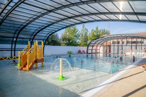 a pool with a water park with a water slide at Camping Harrobia in Bidart