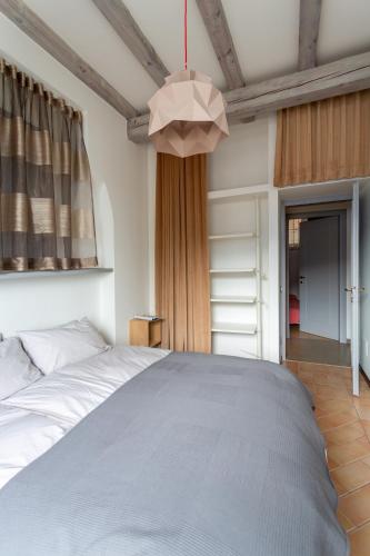 a bedroom with a large bed and a chandelier at La Maison Des Lions APPARTAMENTI VACANZE accesso diretto alla spiaggia località Amore in Cannobio