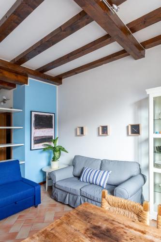 a living room with a blue couch and a table at La Maison Des Lions APPARTAMENTI VACANZE accesso diretto alla spiaggia località Amore in Cannobio