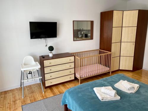 a nursery with a crib and a dresser and a crib at Apartament na Nadmorskiej in Grzybowo