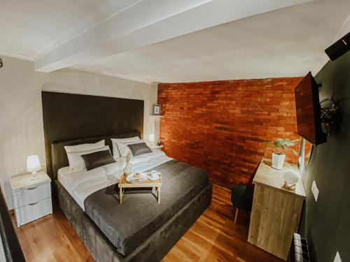 1 dormitorio con 1 cama grande y pared de ladrillo en Luxury inn en Tiflis