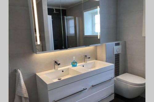 a bathroom with a sink and a toilet and a mirror at Comfortable house in quiet area in Luster