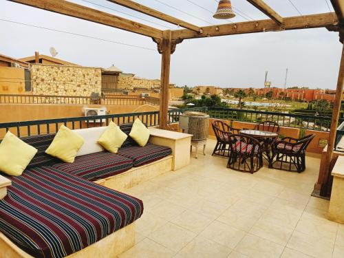 a patio with a couch and a table and chairs at Marina wadi degla villa duplex Ain Sokhna in Ain Sokhna