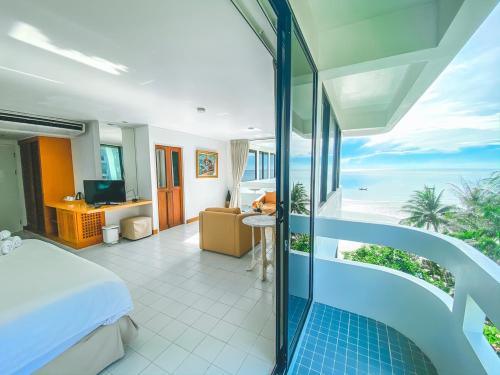 a bedroom with a bed and a view of the ocean at Nern Chalet Beachfront Hotel in Hua Hin