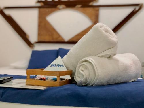 Una toalla enrollada encima de una cama en M&M Apartments Holbox en Holbox Island