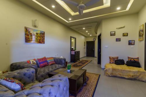 a living room with couches and a table at Serenity Corner in Islamabad