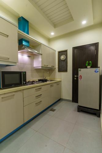 a kitchen with a refrigerator and a microwave at Serenity Corner in Islamabad