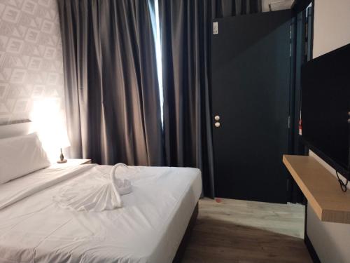 a bedroom with a white bed with a lamp and a window at SRITEL BOUTIQUE HOTEL in Shah Alam