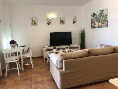 - un salon avec un canapé et une table avec une télévision dans l'établissement Casa Yaiza, à Puerto Calero