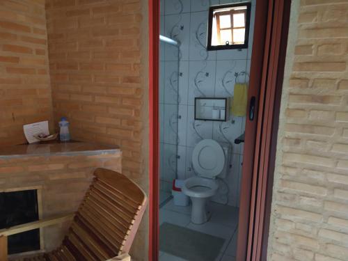 ein Badezimmer mit Toilette neben einem Kamin in der Unterkunft Sitio Pousada Morada do Sol in Cunha