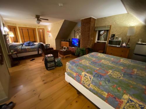 a bedroom with a bed and a living room at Harbor House Hotel by Umaniii in Jonesport Maine in Jonesport