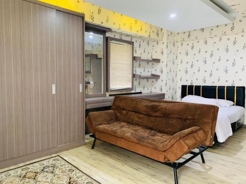 a living room with a couch and a bed at Apartemen Cibubur Village by Raja Sulaiman Property in Cibubur