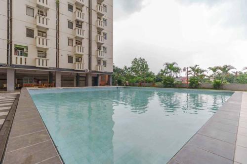 a swimming pool in front of a building at Apartemen Cibubur Village by Raja Sulaiman Property in Cibubur