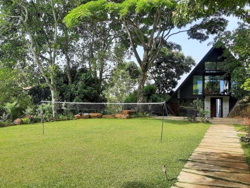 a net in a yard with a house at GlenMyu Estate in Haputale