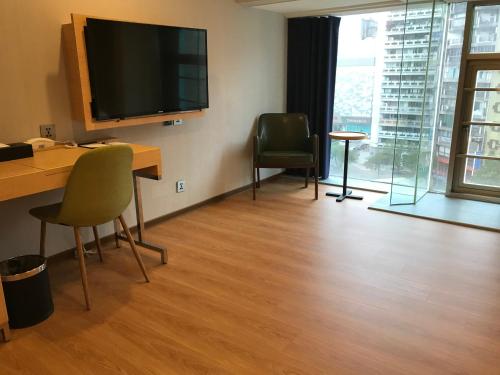 a room with a desk and a television on a wall at Hej Taipei in Taipei