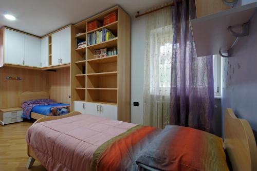 1 dormitorio con cama y estante para libros en Cuore nel Muller, en Giovo