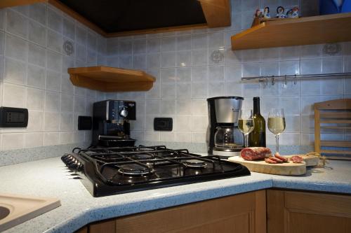 a kitchen with a stove and some glasses of wine at Cuore nel Muller in Giovo