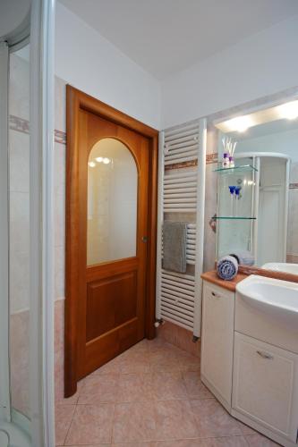 a bathroom with a wooden door and a sink at Cuore nel Muller in Giovo