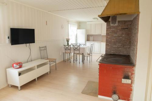 a kitchen and living room with a brick oven at Villa Jukola in Teijo