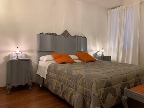 una camera da letto con un letto con cuscini arancioni sopra di Le stanze di Anna Rita all'Arco Polinori a Foligno