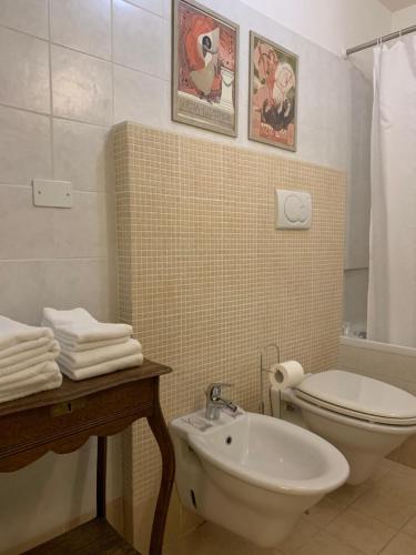 bagno con servizi igienici bianchi e lavandino di Le stanze di Anna Rita all'Arco Polinori a Foligno