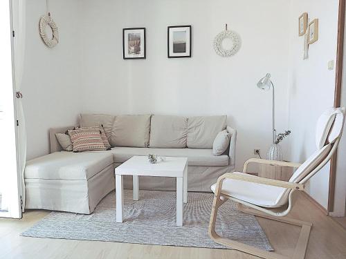 a living room with a couch and a table and a chair at Eco Apartments Kate in Suđurađ