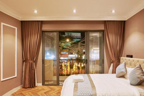 a bedroom with a large bed and a balcony at The Alcove Apartment Vung Tau in Vung Tau