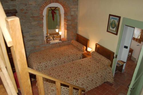 a bedroom with two beds and a mirror at Torre BALDUCCI in Vicopisano