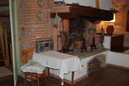 a room with a brick fireplace with a table and a stove at Torre BALDUCCI in Vicopisano