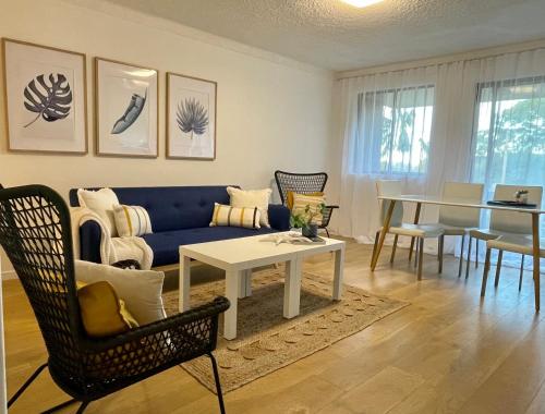 a living room with a blue couch and a table at Kiama Palms on Collins in Kiama