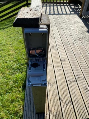 un teléfono público sentado en un banco de madera en Loch Morar Private Suite, en Mallaig