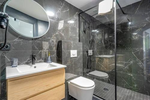 a bathroom with a sink and a toilet and a mirror at Charmant T2 climatisé - Canebière et Vieux-Port in Marseille