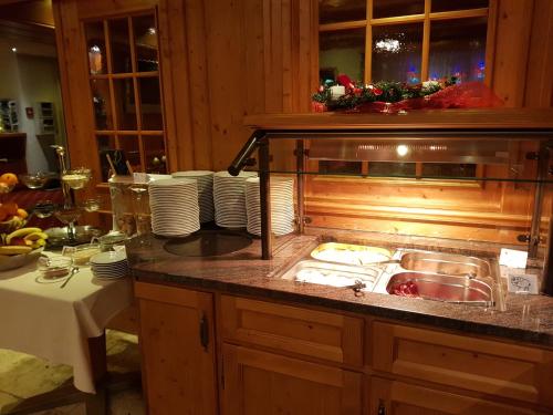 a kitchen with a sink and a counter with plates at Hotel Taescherhof in Täsch